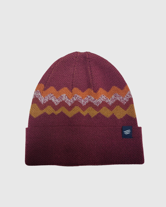 Burgundy Merino Wool Mountain Scape Knit Beanie (Front): Dark red knit beanie with zigzag mountain pattern in orange, white, and gold
