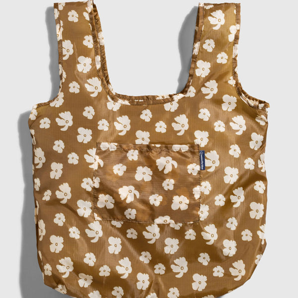Smoky Ochre The Packable Tote (Flat-lay): Golden brown tote with white floral print, wide straps, and front pocket