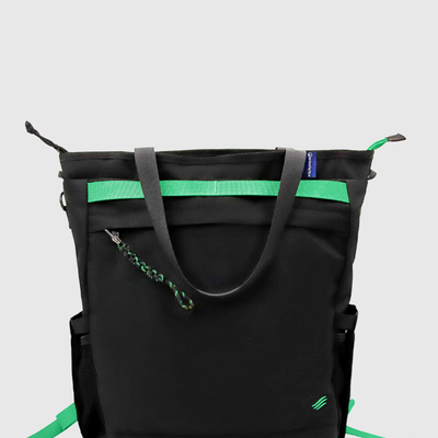 Black Multi (R)evolution™ 25L Convertible Carryall (Back): Black tote with gray handles, green webbing stripe, and zipper pull