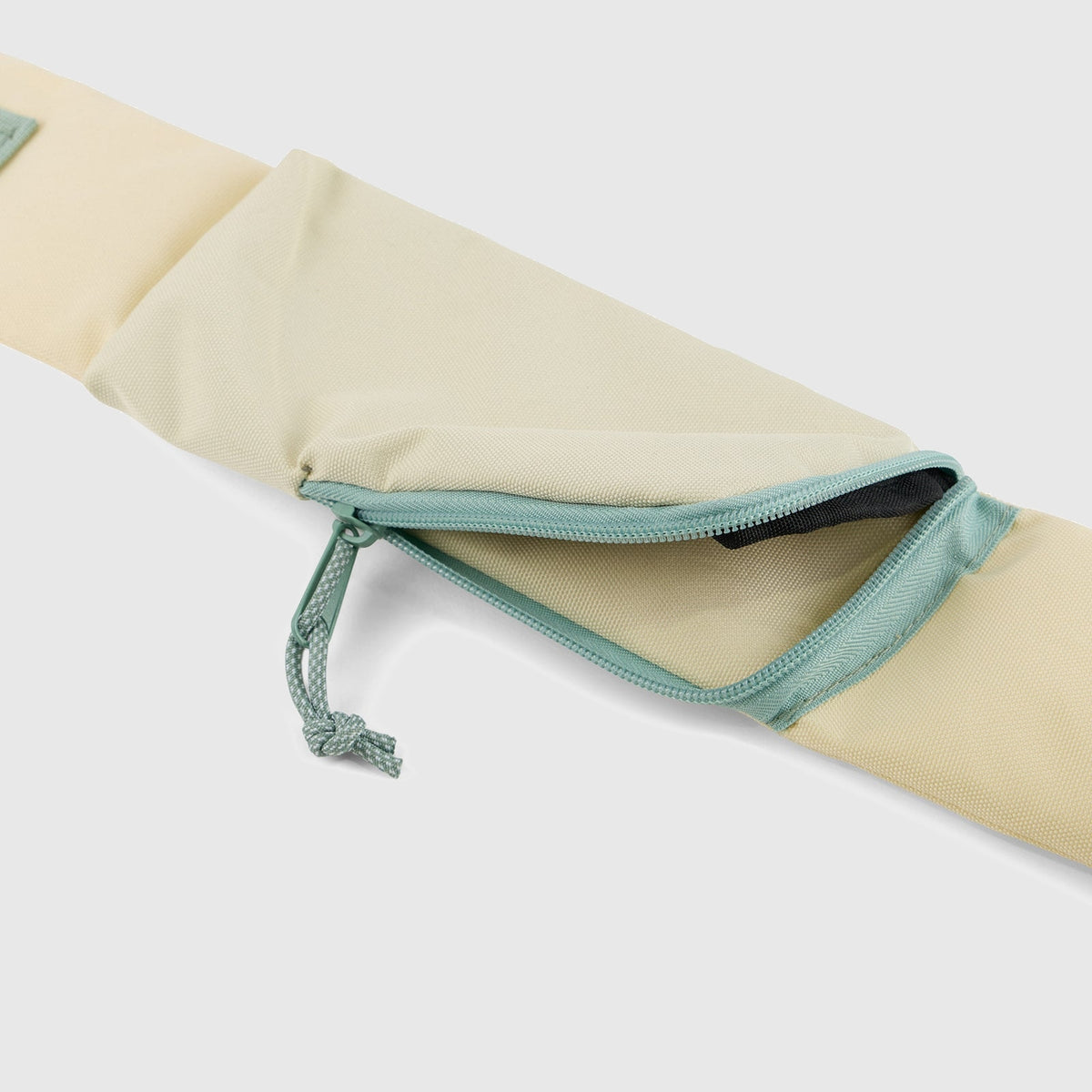Pink Multi (R)evolution Sling Pack (Detail): Close-up of open zippered pocket with teal zipper on beige fabric