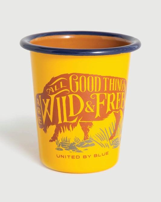 WILD AND FREE WILD AND FREE – 12OZ. ENAMEL TUMBLER (Angle): Yellow enamel tumbler with navy rim and brown bison graphic text
