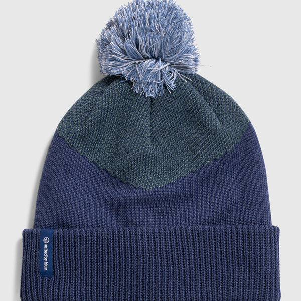 NAVY Recycled Chevron Pom Beanie (Flat-lay): Navy knit beanie with dark teal chevron pattern and light blue pom
