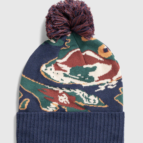 Lakeside Camo Recycled Novelty Pom Beanie (Flat-lay): Navy knit beanie with multicolor duck print and mixed pom-pom on top