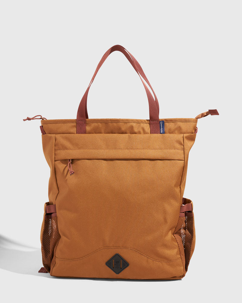 Camel (R)evolution™ 25L Convertible Carryall (Front): Tan tote with rust handles, front zip pocket, and mesh side pockets