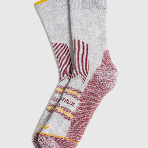 Red Bison Wool Trail Sock (Angle): Light grey crew socks with burgundy heel, toe, and stripe accents, yellow cuff trim