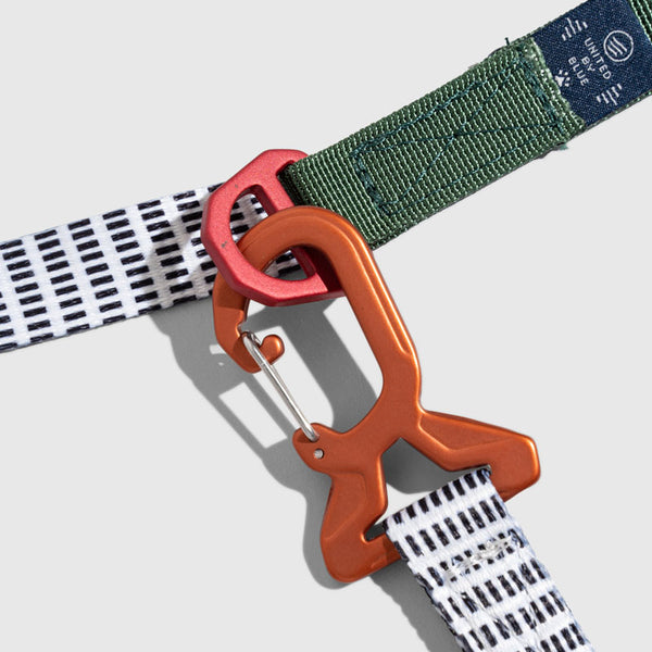 Shortbread (R)evolution™ Recycled Woven Dog Leash (Detail): Orange carabiner clip connects white grid-pattern strap to green webbing leash