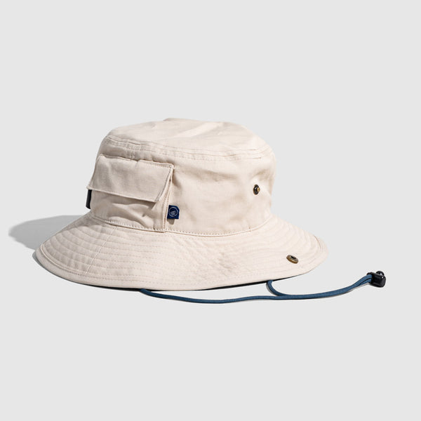 Bone Organic Bucket Stash Hat (Angle): Off-white boonie hat with side pocket, brass eyelets, and navy chin cord