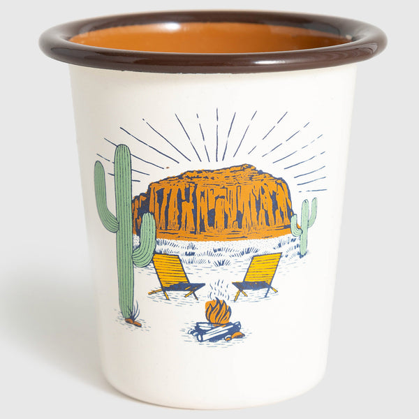 Cream Desert Chill Enamel 12 Oz. Tumbler (Angle): White enamel tumbler, brown rim, desert scene with mesa, cacti, campfire