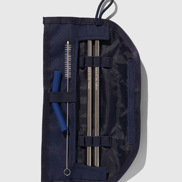 Navy The Straw Kit (Flat-lay): Open navy pouch with two metal straws, cleaning brush, and silicone tips