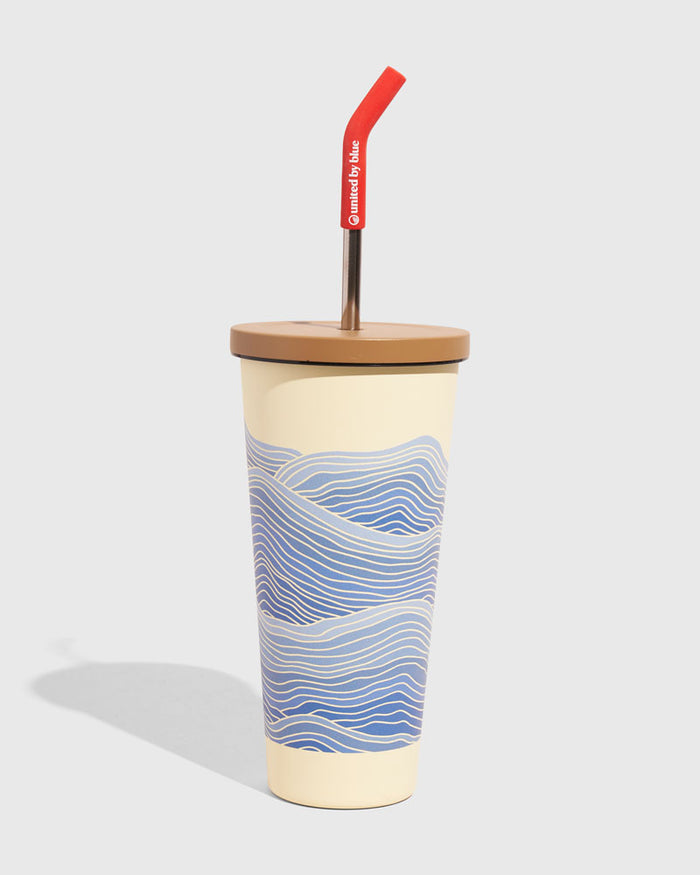 Eggshell - Waves 24 oz Insulated Steel Straw Tumbler (Angle): Cream tumbler with blue wave print, tan lid, red-tipped metal straw