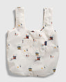 Tusk The Packable Tote (Flat-lay): White tote with small ice fishing hut and dog repeat print, front pocket