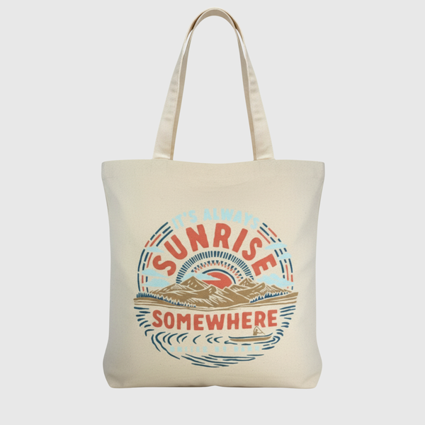 It's Always Sunrise Somewhere My Favorite Daily Tote (Front): Natural canvas tote with circular sunrise landscape graphic in red, blue, tan