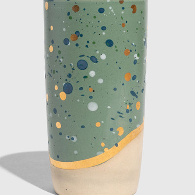 Juniper 10 oz. Insulated Stoneware Travel Mug (Angle): Sage green speckled tumbler with gold band and unglazed cream base