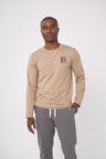 Ash Earth Circle - Long-Sleeve Graphic Tee (In-use): Man wearing tan long-sleeve tee with small chest globe graphic