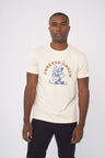 Shortbread Forever Green Graphic Tee (In-use): Man wearing cream tee with blue dancing tree cartoon and gold arc text