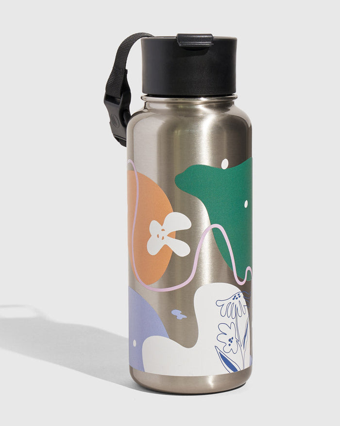 Illuminate Bottle - 23 Oz. Insulated Stainless Steel (Angle): Silver stainless bottle with colorful abstract shapes, black flip-top lid, strap
