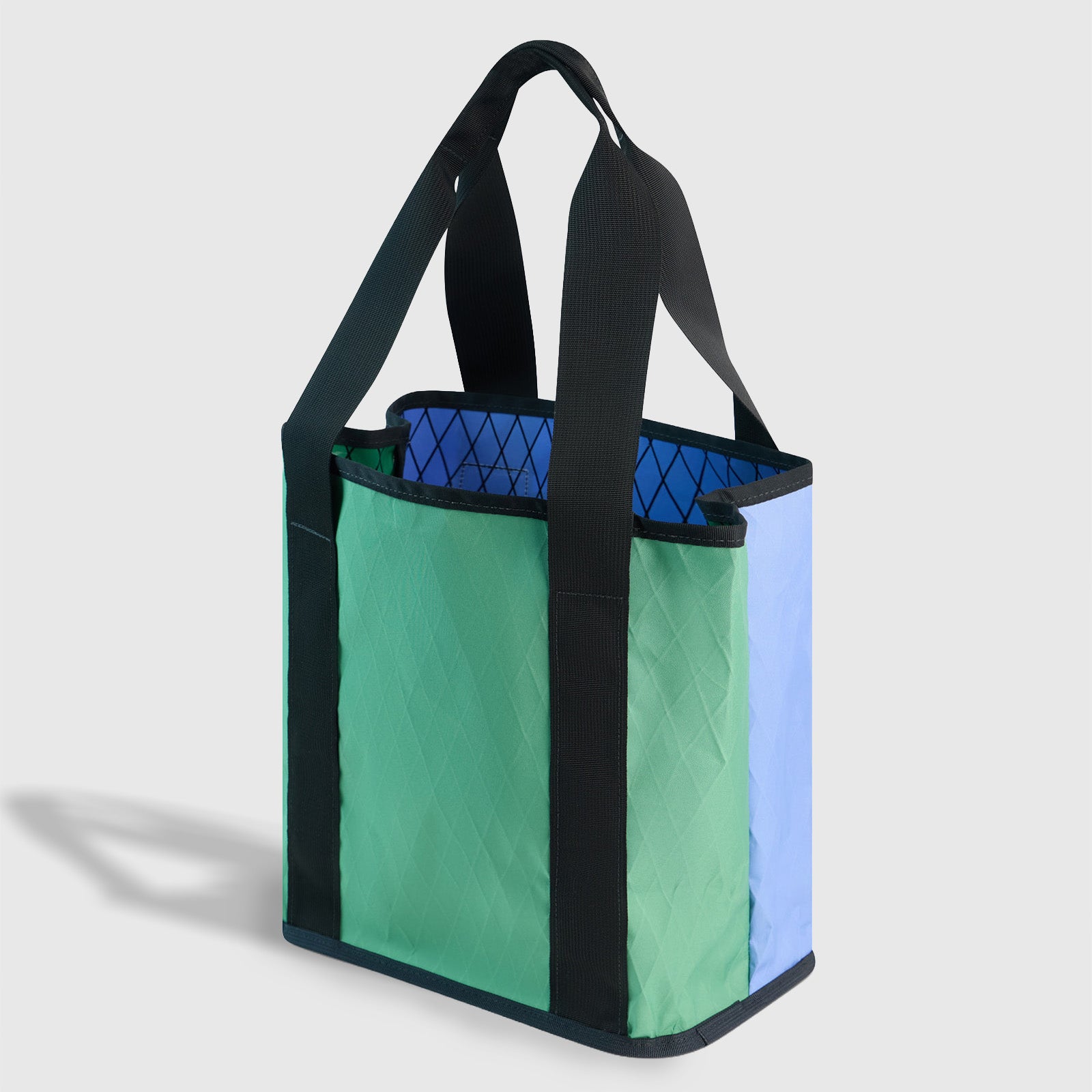 Plum Blue The Westward Tote (Angle): Structured tote with green front, periwinkle side, black handles and trim