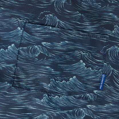 Waves The Packable Tote (Detail): Close-up of navy fabric printed with hand-drawn ocean wave illustrations and front pocket seam