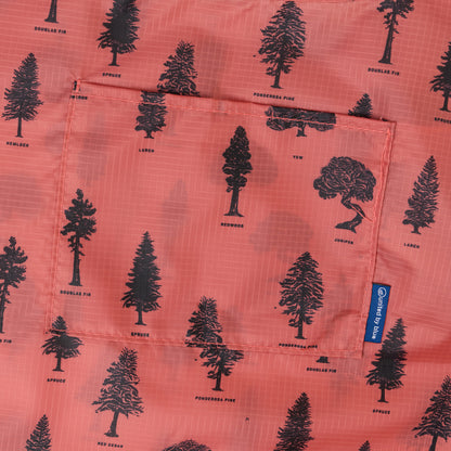 Clay The Packable Tote (Detail): Close-up of rust-orange fabric with labeled black tree silhouettes including Douglas Fir and Ponderosa Pine