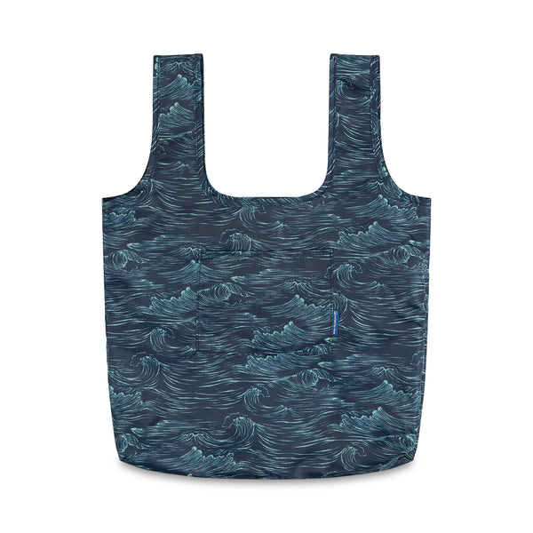 Waves The Packable Tote (Front): Navy packable tote with white ocean wave print, two long straps, and front patch pocket