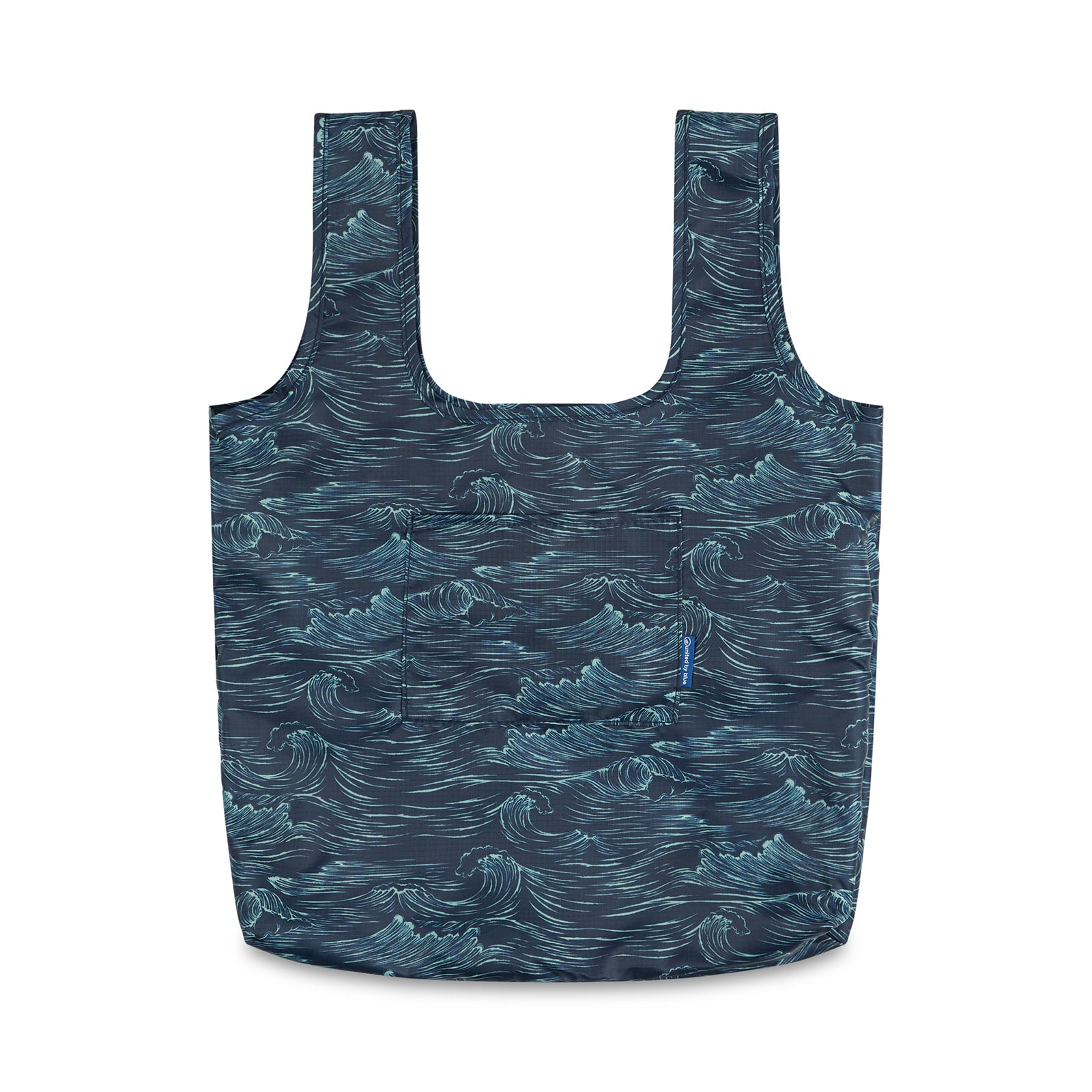Waves The Packable Tote (Front): Navy packable tote with white ocean wave print, two long straps, and front patch pocket