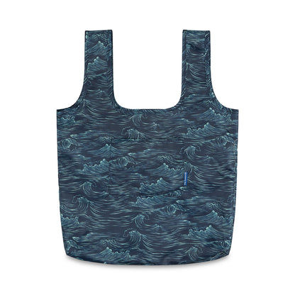 Waves The Packable Tote (Front): Navy packable tote with white ocean wave print, two long straps, and front patch pocket