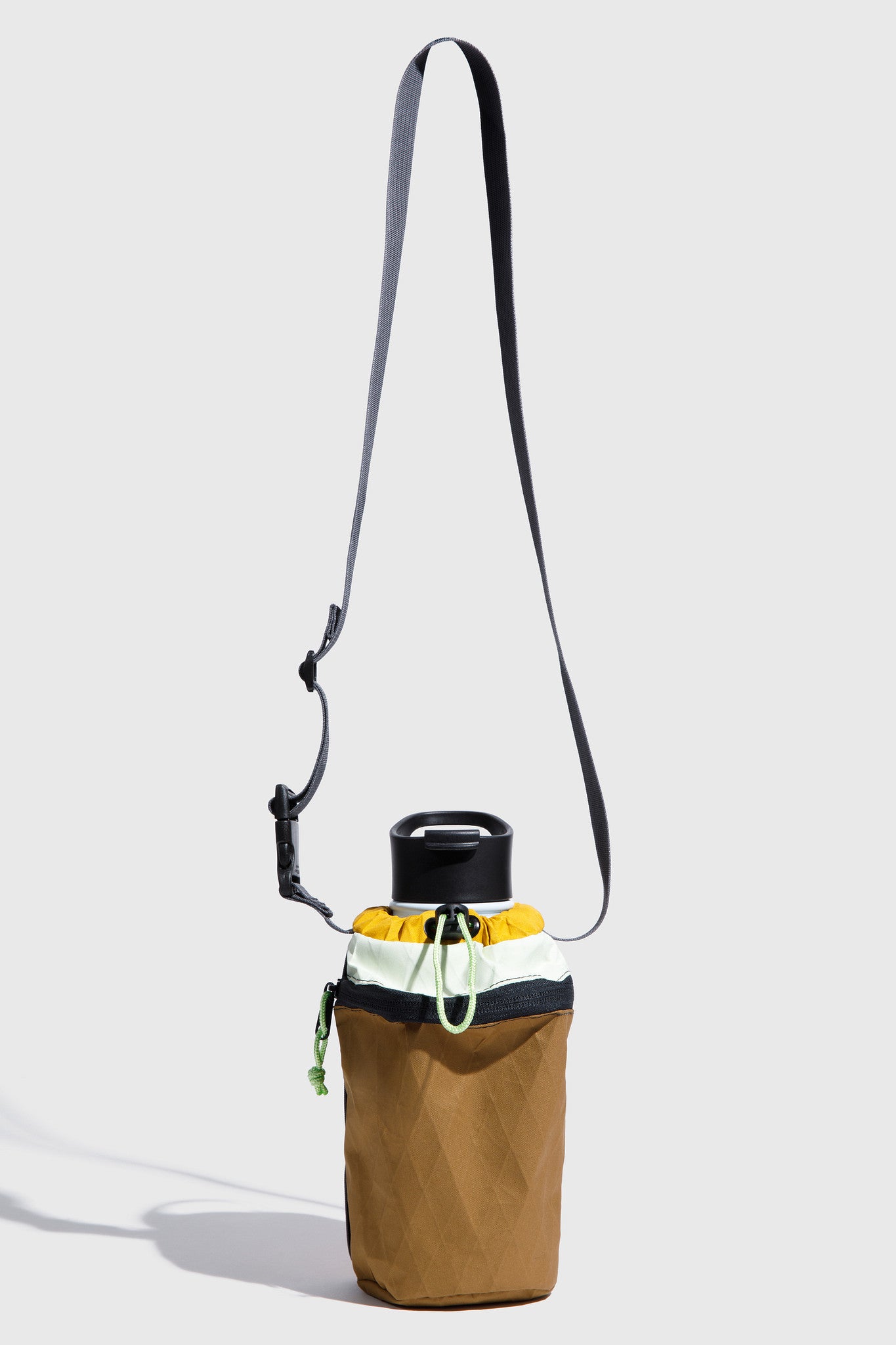 Brown bag with a drawstring and black strap on a light gray background