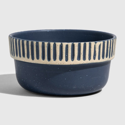 Slate Stoneware Stackable Bowl (Angle): Round navy blue ceramic bowl with cream ribbed stripe near rim