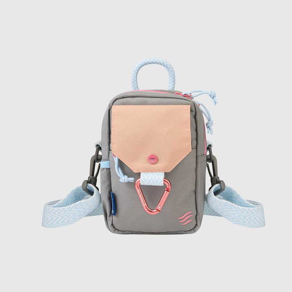 Lt Grey (R)evolution Daily Cross Body (Front): Grey crossbody bag with peach snap-flap pocket, pink carabiner, blue rope handle, chevron strap