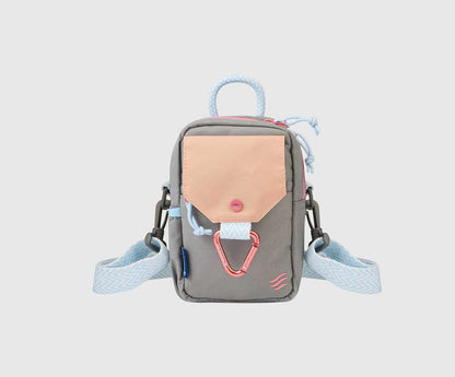 Lt Grey (R)evolution Daily Cross Body (Front): Grey crossbody bag with peach snap-flap pocket, pink carabiner, blue rope handle, chevron strap