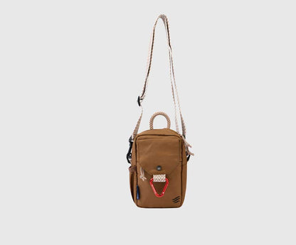 Tigers Eye (R)evolution Daily Cross Body (Side): Tan crossbody hanging from chevron strap showing full silhouette and snap-flap front pocket