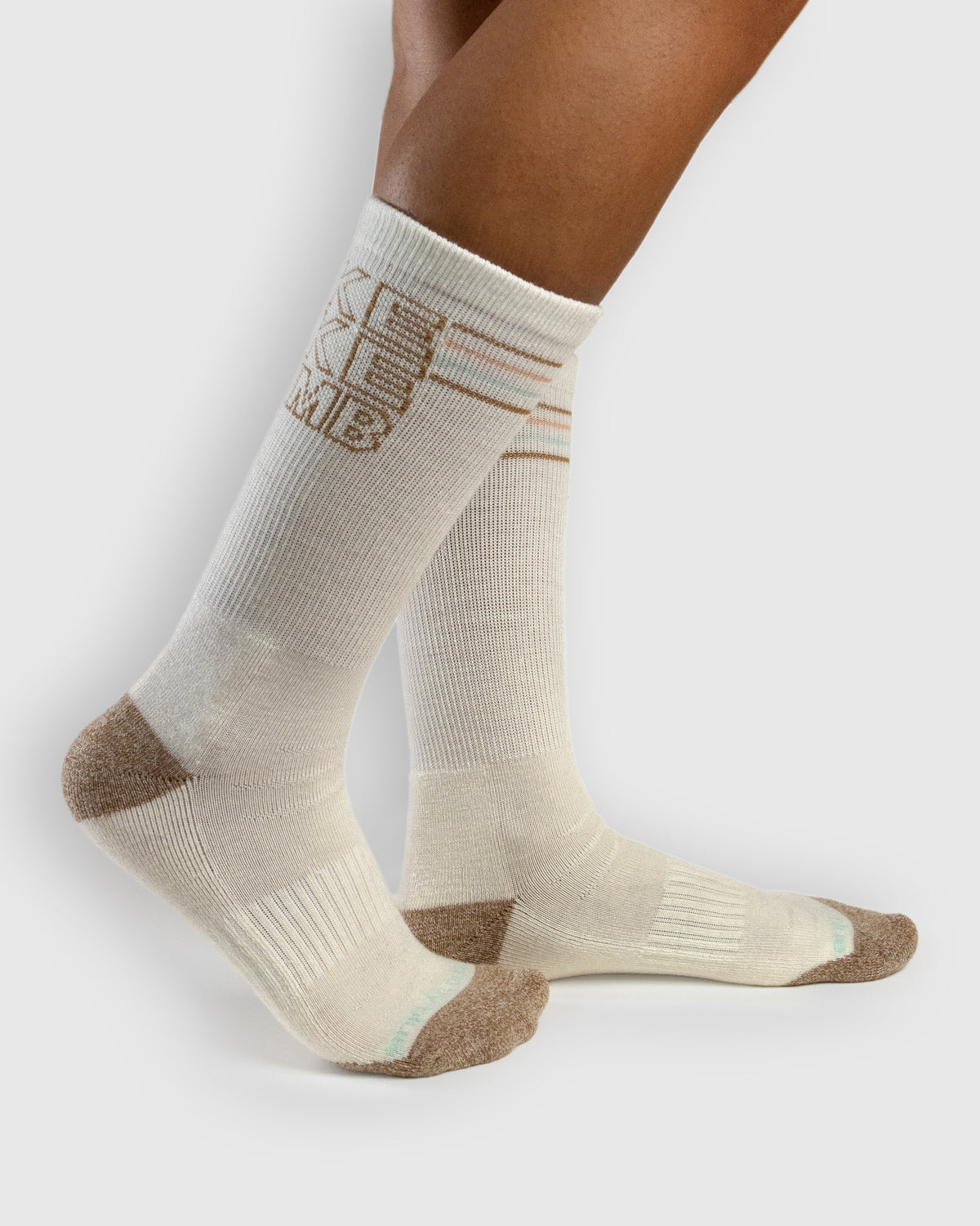 HikeBikeClimb - Natural Merino Wool - Graphic Crew Sock (In-use): Cream graphic merino crew socks worn on feet, side view
