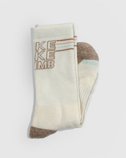 HikeBikeClimb - Natural Merino Wool - Graphic Crew Sock (Detail): Folded cream crew sock showing knit text graphic and brown toe