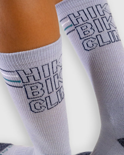 HikeBikeClimb - Periwinkle Merino Wool - Graphic Crew Sock (Close-up): Close-up of periwinkle sock knit HIKE BIKE CLIMB text and teal stripe