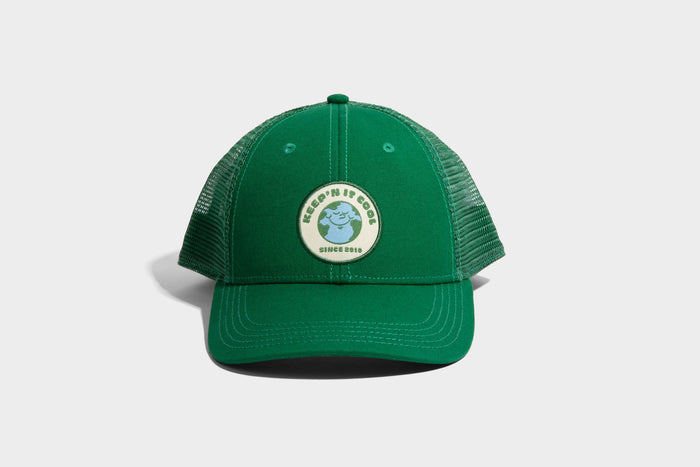 PINE ORGANIC TRUCKER HAT (Front): Green trucker cap with mesh back and circular Earth patch reading Keep'N It Cool Since 2018