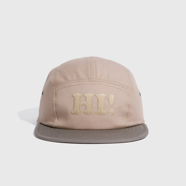 Tan Hi Organic 5-Panel Hat (Angle): Tan five-panel cap with embroidered HI! text and darker gray brim