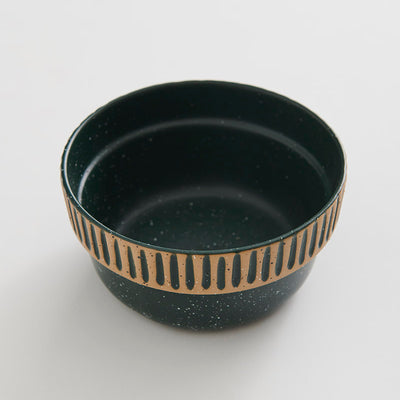 Pine Stoneware Stackable Bowl (Angle): Dark green speckled bowl with tan carved stripe pattern around exterior
