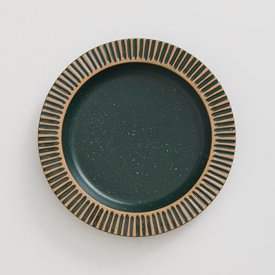 Pine Stoneware Stackable Plate (Flat-lay): Round dark green speckled plate with carved tan ribbed border pattern