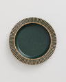 Pine Stoneware Stackable Plate (Flat-lay): Round dark green speckled plate with carved tan ribbed border design