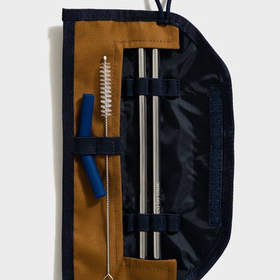 Camel The Straw Kit (Flat-lay): Open navy roll case with two steel straws, brush, and blue tip