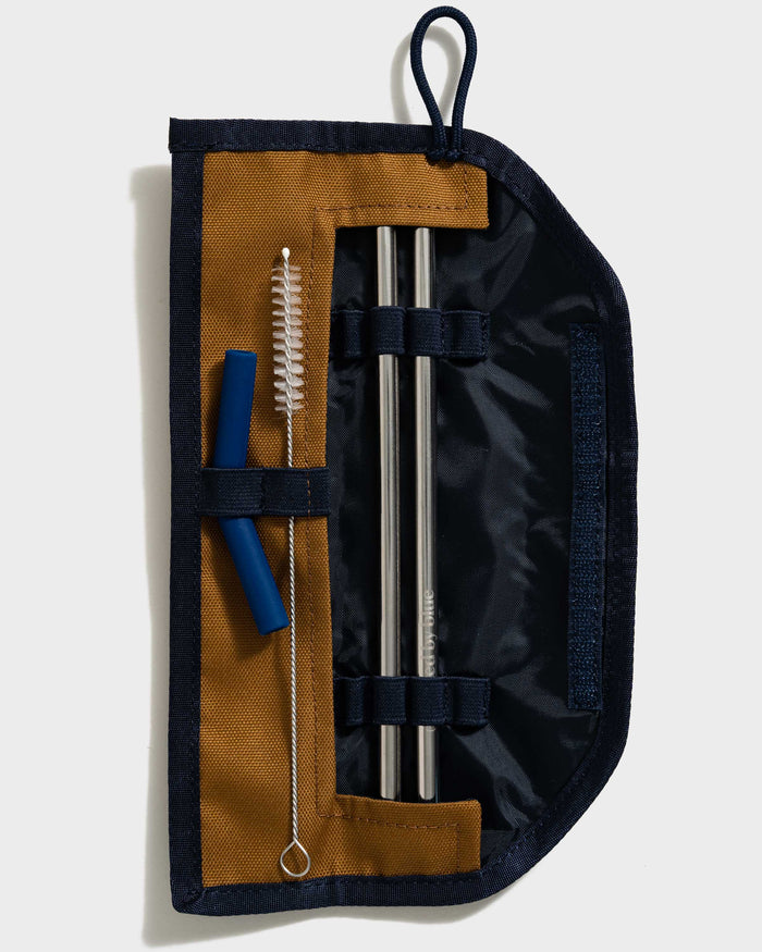 Camel The Straw Kit (Flat-lay): Open navy roll revealing two steel straws, blue silicone tip, and cleaning brush