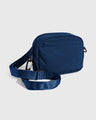 Blueberry (Re)active™ 2L Convertible Crossbody (Angle): Navy blue crossbody bag with front zip pocket and adjustable strap