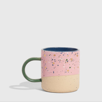 Lilac 8 oz. Stoneware Mug (Angle): Pink speckled exterior, unglazed sandy base, green handle, navy interior