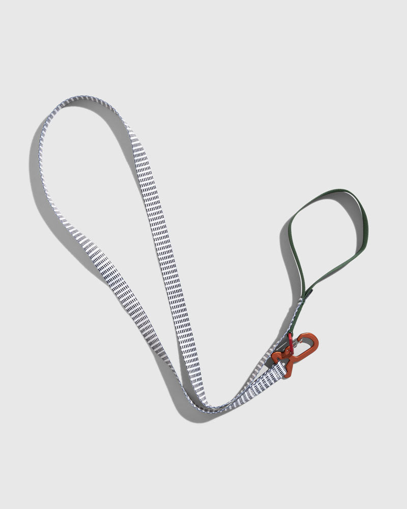 Shortbread (R)evolution™ Recycled Woven Dog Leash (Flat-lay): White woven leash with dark dash pattern, green handle loop, orange clip