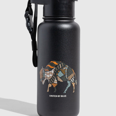 Black Ink Insulated Steel Bottle 32 Oz. (Angle): Matte black bottle with colorful patchwork bison graphic and carrying strap