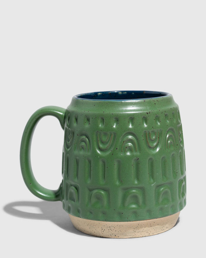 Pine 16 oz. Stoneware Mug (Angle): Green speckled stoneware mug with embossed arch pattern and navy interior