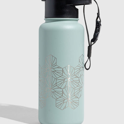 Juniper Insulated Steel Bottle 32 Oz. (Angle): Mint green steel bottle with silver geometric hexagon pattern and black lid