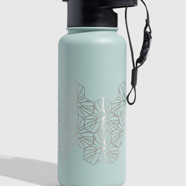Juniper Insulated Steel Bottle 32 Oz. (Angle): Mint green steel bottle with silver geometric hexagon pattern and black lid