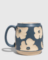 Eclipse Blue 16 oz. Stoneware Mug (Angle): Blue speckled stoneware mug with raised cream floral pattern and loop handle