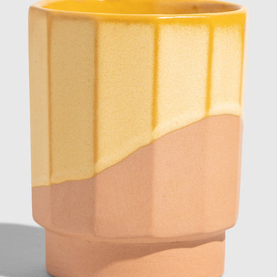 Honey 8 oz. Stackable Stoneware Tumbler (Angle): Faceted tumbler with yellow glaze dripping over unglazed terracotta base